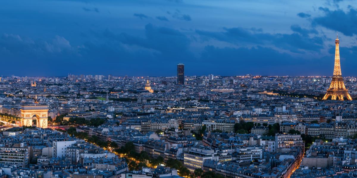 Nighttime view of Paris, France with the Eiffel Tower, Arc de Triomphe, and Sacre Coeur- How to Find the Cheapest Flights to Europe